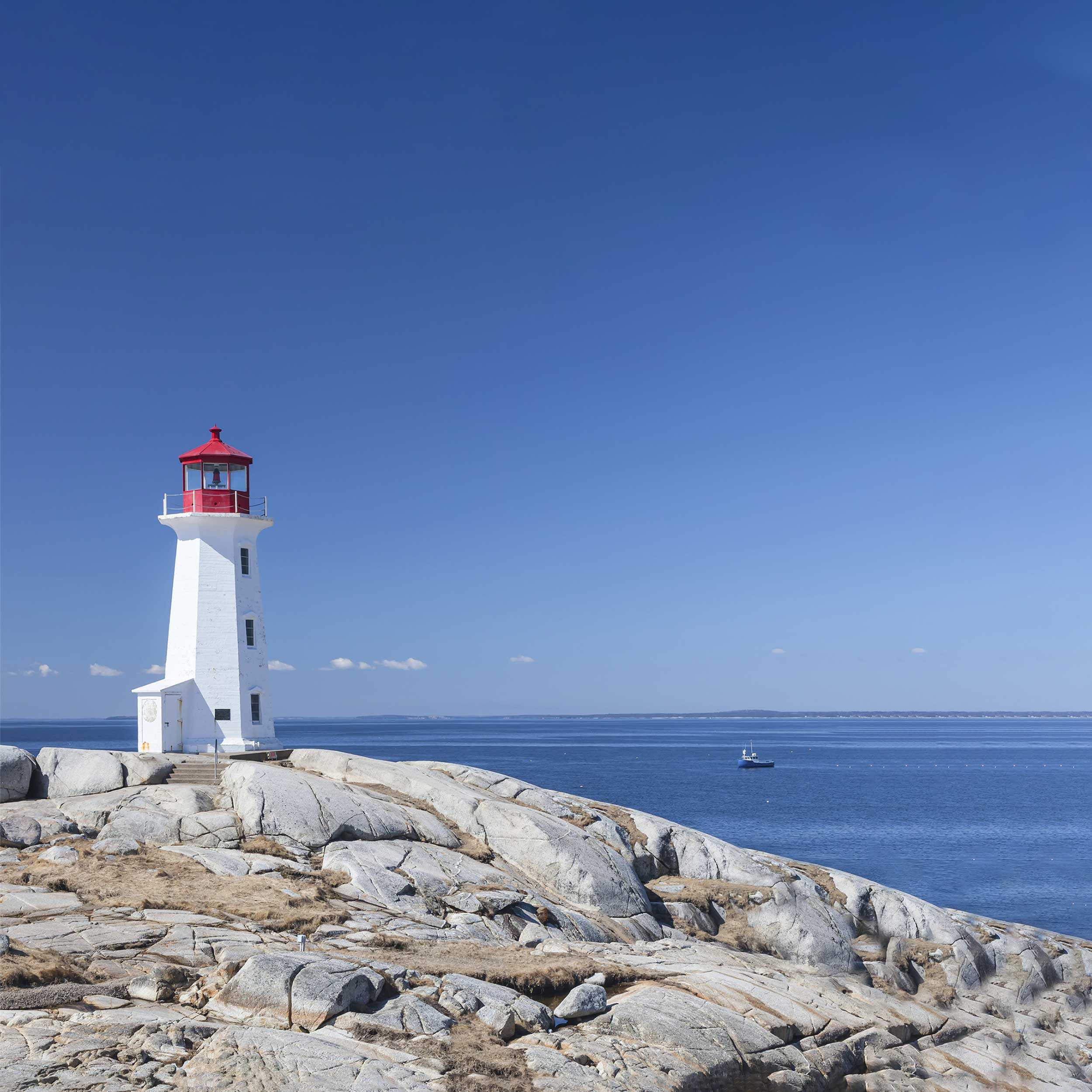 white lighthouse on rocky shore